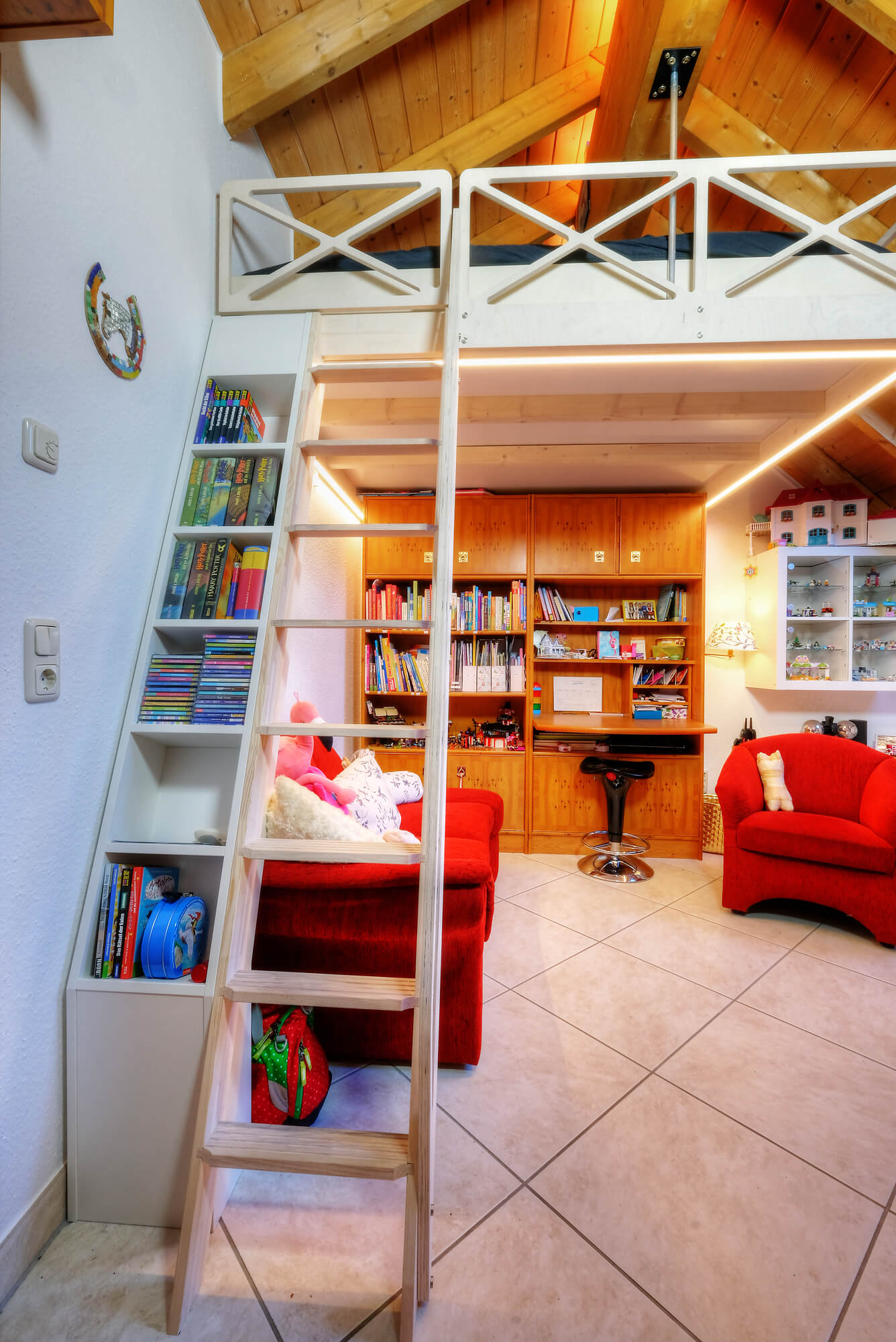 ...hat parallel zur Leiter ein Bücherregal und am Eingang ein Türchen.