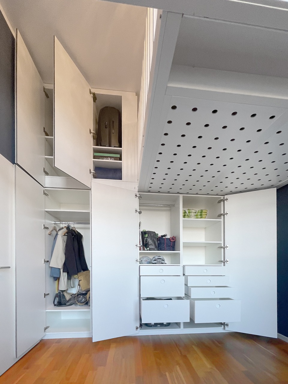 CLAUDIAS UND GEORGS HOCHETAGE Der schrank verfügt über Böden, Stangen und Schubfächer.